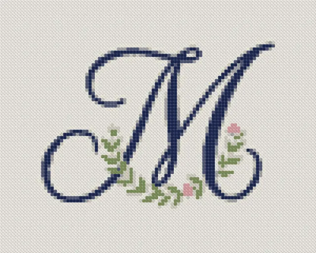 Cross stitch pattern of a script letter M with a small wreath of leaves and rosebuds